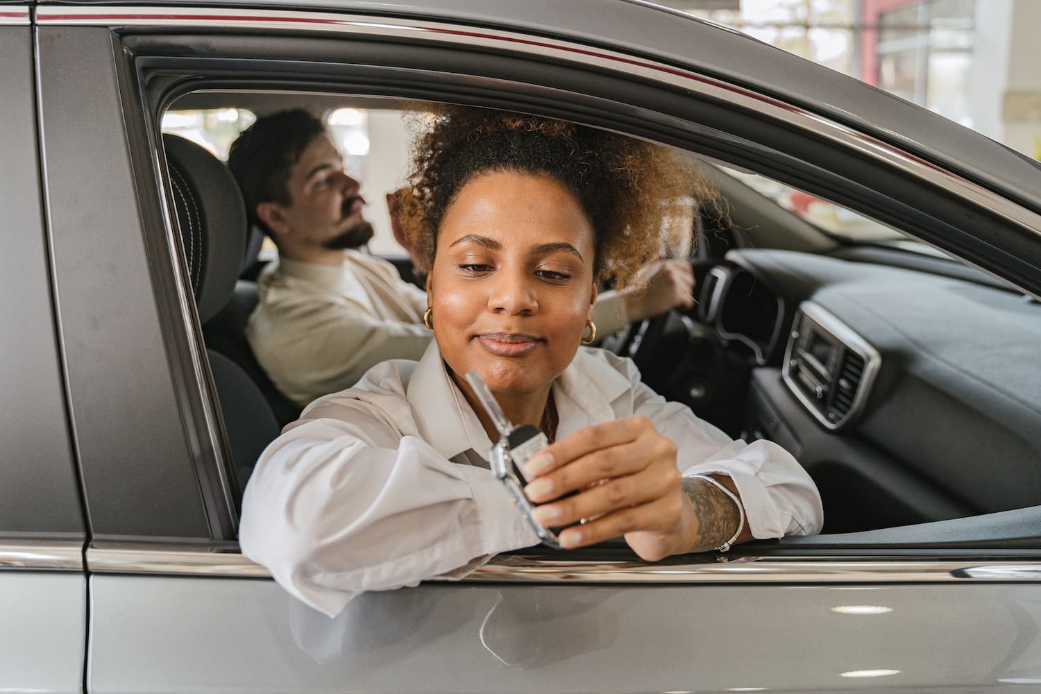Conductrice tenant les clés de sa voiture de location à la portière